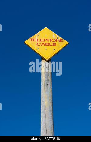 Segnale di informazione giallo avvertenza del cavo telefonico su Aldeburgh Beach Foto Stock