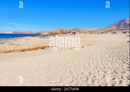 Vista sulla splendida spiaggia di Papagayo vicino alla città di Playa Blanca, Lanzarote, Isole Canarie. Vista mare blu, sabbia gialla, fuoco selettivo Foto Stock