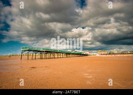 Molo di St. Annes, Lancashire, sotto una nuvola minacciosa in una giornata di sole Foto Stock