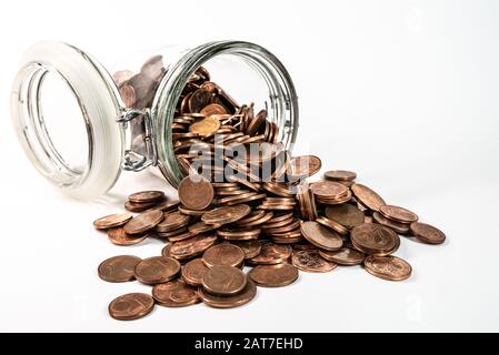 piccole monete euro cent cambio che si riversano dal vaso di vetro isolato su sfondo bianco, ritiro del concetto di monete a bassa denominazione Foto Stock