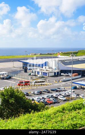 Ponta Delgada, Azzorre, Portogallo - 14 Gennaio 2020: Vista Dell'Aeroporto Di Joao Paulo Ii Nell'Isola Di Sao Miguel. Pista con un aereo, costruzione del terminal e parcheggio per auto a noleggio. Oceano sullo sfondo. Foto Stock