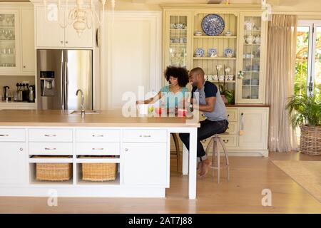 Felice giovane coppia seduto al tavolo in cucina Foto Stock