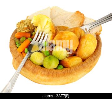 Cena di pollo arrosto in un grande budino dello Yorkshire isolato su uno sfondo bianco Foto Stock