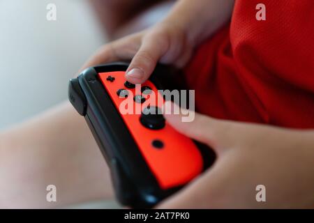 Bambino che gioca con un controller Nintendo Switch Foto Stock