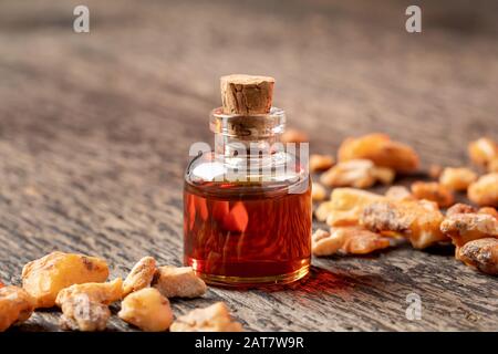 Una bottiglia trasparente di olio essenziale di benzoino styrax su un tavolo Foto Stock