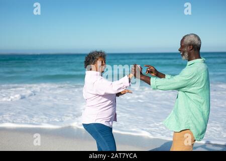 Vecchia coppia divertirsi in spiaggia Foto Stock