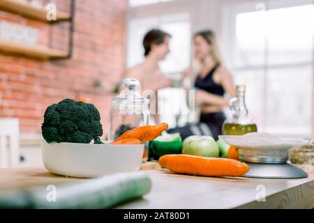 dieta, alimentazione sana, stile di vita di idoneità, nutrizione adeguata. coppia cosciente di salute che beve frullato fresco nella cucina domestica. Foto Stock