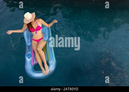 Giovane donna rilassante in piscina Foto Stock