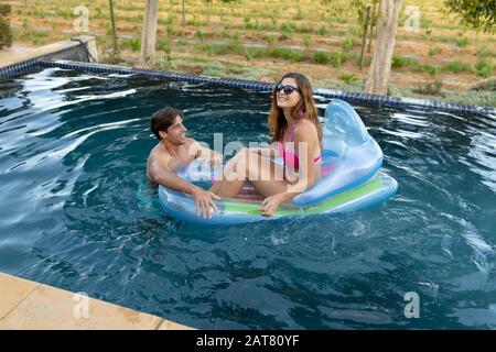 Felice giovane coppia rilassante in piscina Foto Stock