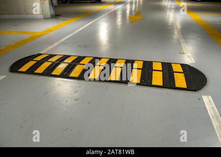 Urto rapido nero e giallo a strisce su strada. Foto Stock