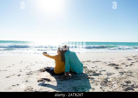 Coppia che prende selfie alla spiaggia Foto Stock
