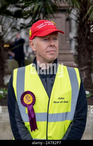 Londra, Regno Unito. 31 Gennaio 2020. Pro-Brexit e sostenitore dell'UKIP indossano una giacca gialla ad alta visibilità e una cappellino rosso da baseball 'Rendi l'America Grande Di Nuovo'. Foto Stock