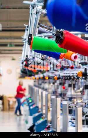 Filo a mulinello colorato, realizzato con macchine da cucire o da ricamo moderne e automatiche, concetto di fabbrica dell'industria tessile Foto Stock