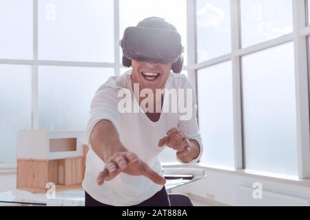 Sorridente giovane in un casco di realtà virtuale e ciò Foto Stock