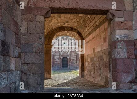 Passaggio che porta alla chiesa di nostra Signora di Tergu, XI secolo, romanica, nel villaggio di Tergu, vicino Castelsardo, provincia Sassari, Sardegna, Italia Foto Stock