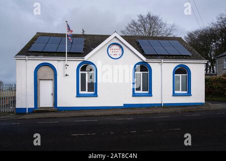 Bandiera dell'Unione che vola su un piccolo villaggio Orange Hall nella contea di Dervock Antrim Irlanda del Nord Foto Stock