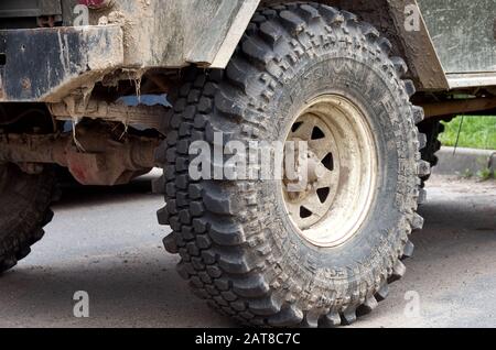 Ruote sporche e sospensione di un vecchio SUV parcheggiato Foto Stock