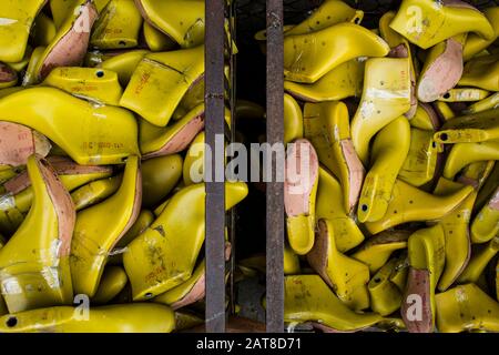 Angolo di chiusura elevato di contenitori di stampi per scarpe gialli in una fabbrica. Foto Stock