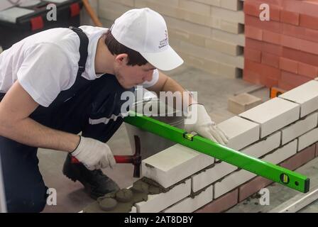 Giovane muratore esegue un compito della concorrenza Foto Stock