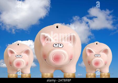 Tre piggybank in piedi su monete euro Foto Stock