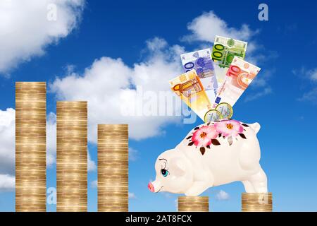 Piggybank con banconote in circolazione su monete in euro Foto Stock