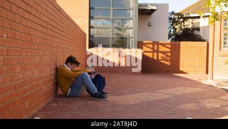 Ragazzo adolescente seduta nella scuola Foto Stock