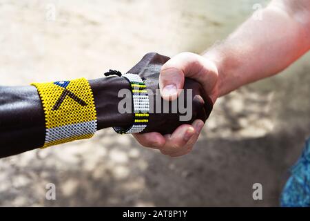 Stretta di mano di uomini africani ed europei o americani. Il concetto di amicizia e relazioni commerciali tra paesi e continenti. Foto Stock