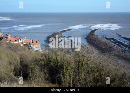 Una vista della Baia di Robin Hood e del Mare del Nord con bassa marea, North York Moors National Park, Yorkshire, Inghilterra, Regno Unito. Foto Stock