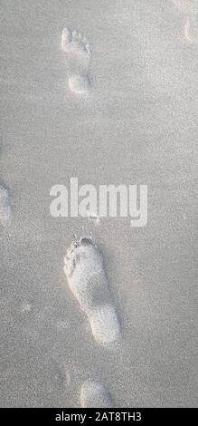 Orme nella sabbia sulla spiaggia Foto Stock
