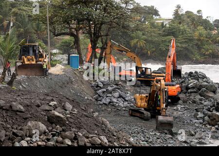 Attrezzature pesanti che costruiscono un muro di mare a Matelot, sulla costa nord-orientale di Trinidad, Trinidad e Tobago Foto Stock