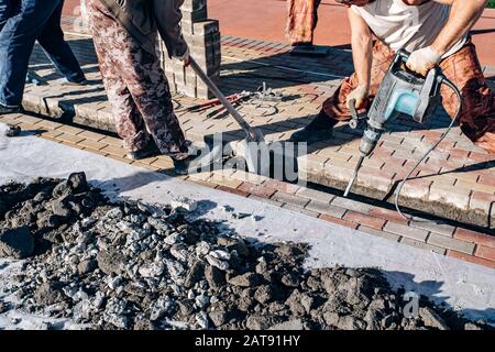 I lavoratori di cui pavimentazione in lastre. Due lavoratori laici di lastre per pavimentazione. Foto Stock