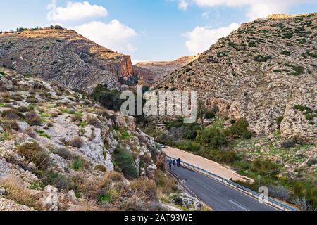 i turisti che ritornano dal monastero di faran nella riserva di ein prat nella riva occidentale seminando il canyon e la vecchia stazione di pompaggio britannica e le rovine di un Foto Stock