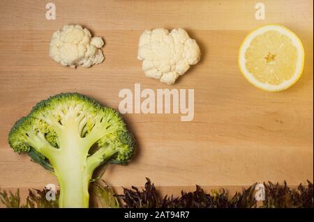 broccoli, cavolfiori sotto forma di nuvole e un limone sotto forma di sole Foto Stock