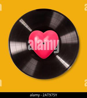 Disco in vinile nero isolato su sfondo giallo , concetto di giorno valentines Foto Stock