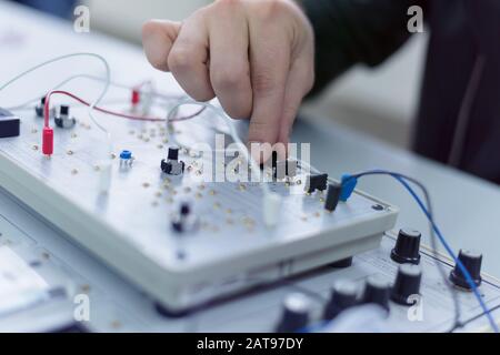 Studenti di ingegneria che lavorano in laboratorio. Gli studenti stanno regolando i componenti elettrici all'interno del laboratorio. Foto Stock