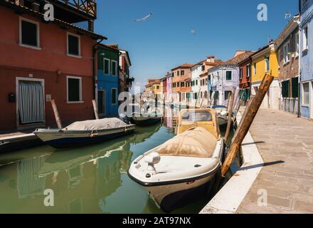 Case colorate a Burano lungo il canale e le barche, Venezia, Italia Foto Stock