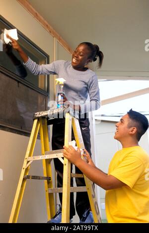 Austin, Texas: 13 anni ispanico ragazzo e African American ragazza lavano le finestre. ©Bob Daemmrich Foto Stock