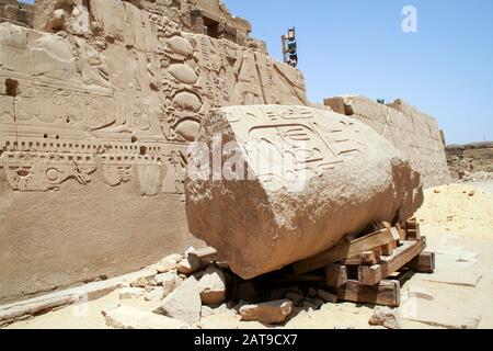 Luxor, Karnak, Egitto, Africa. Tempio di Karnak. Particolare dei geroglipnici sulle pareti e una pietra in un'area di restauro attivo del tempio. Foto Stock
