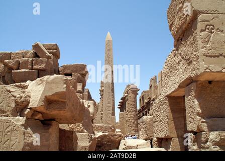 Luxor, Karnak, Egitto, Africa. Tempio di Karnak. Geroglipnici l'obelisco di Hatshepsut visto attraverso un mucchio di macerie nel tempio. Geroglifici; Foto Stock