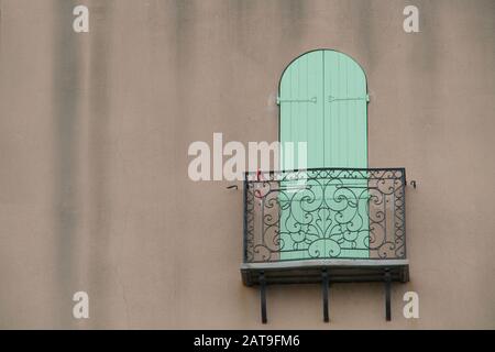 primo piano di una serranda pieghevole verde dietro un balcone in metallo Foto Stock