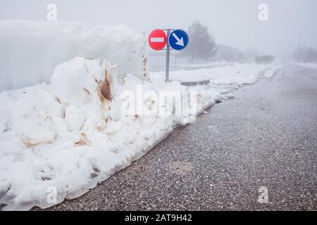 Segnaletica stradale nella nebbia durante una neve bizzard. Foto Stock