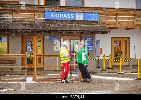 Canazei, Italia - 18 gennaio 2020: Due persone di fronte all'edificio Skipass della funivia di Funivie Belvedere Seilbahnen, nella valle della montagna italiana Foto Stock