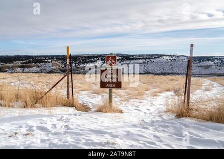 Cartelli segnaletici e recinzioni su una collina ricoperta di neve bianca in inverno Foto Stock