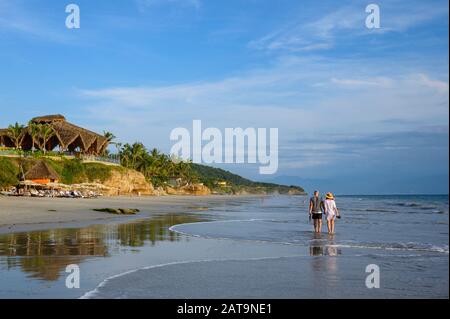 Coppia A Piedi Su Playa Destiladera Al Marival Armony Resort , Riviera Nayarit, Messico. Nota: La coppia ha dato il permesso per le foto. Foto Stock