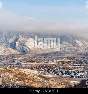 Case a cornice quadrata nei sobborghi circondate da un suggestivo paesaggio montano coperto di neve Foto Stock