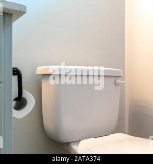 WC con telaio quadrato e mobile da toeletta con supporto per rotolo di  tessuto contro la parete bianca del bagno Foto stock - Alamy