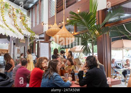 Byron Bay Combi cafe, gli amici si siedono intorno a gustare la colazione e il caffè mentre tengono le conversazioni, Byron Bay, Australia Foto Stock