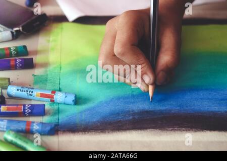 Ritratto di disegno del ragazzo usando matite e pastelli a colori Foto Stock