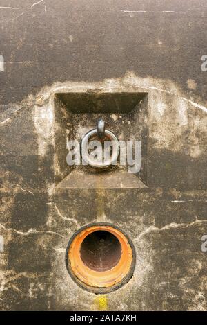 Un anello di ferro e un buco in un muro di cemento a Battery Harvey Allen, Fort Canby, Washington, Stati Uniti Foto Stock