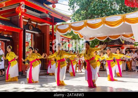 Donne che danzano a Vihara Dharmayana, tempio buddista cinese a Kuta, Bali, Indonesia. Comunità cinese-indonesiana che conduce la cerimonia di Melaspas. Foto Stock